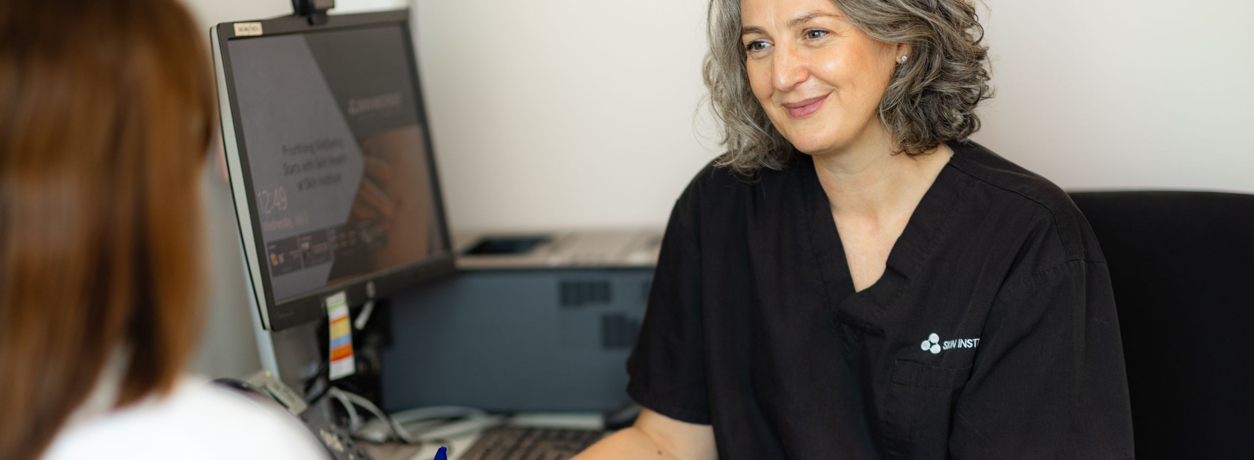 Dr Maya Steeper talking with a patient about their veins in a consultation